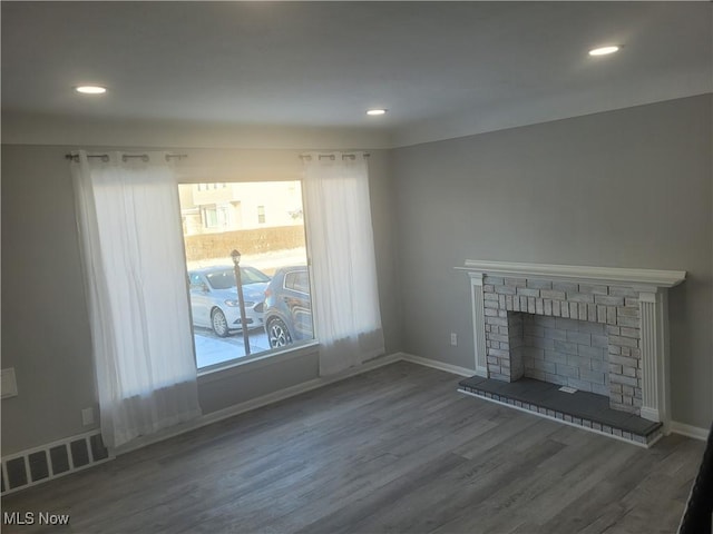 unfurnished living room featuring hardwood / wood-style flooring and a fireplace