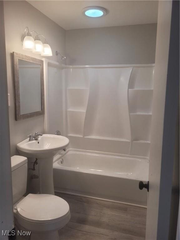 bathroom featuring hardwood / wood-style floors, toilet, and shower / washtub combination