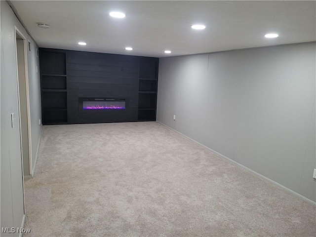 basement with light carpet and a large fireplace