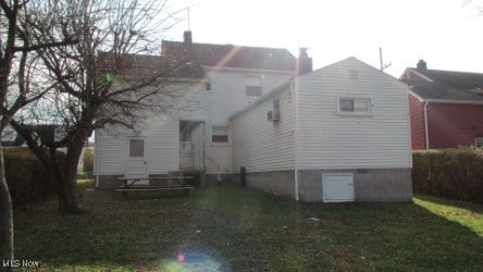 rear view of property featuring a yard