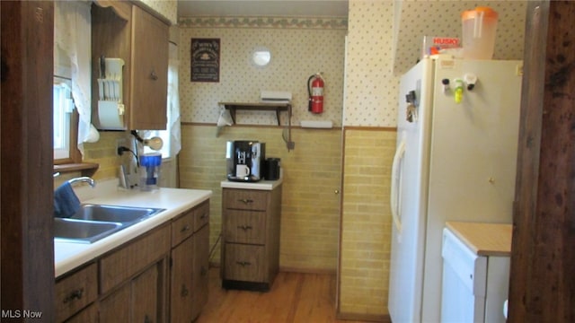 kitchen featuring sink, white fridge, and light wood-type flooring