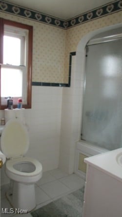 bathroom with walk in shower, tile patterned flooring, vanity, and toilet