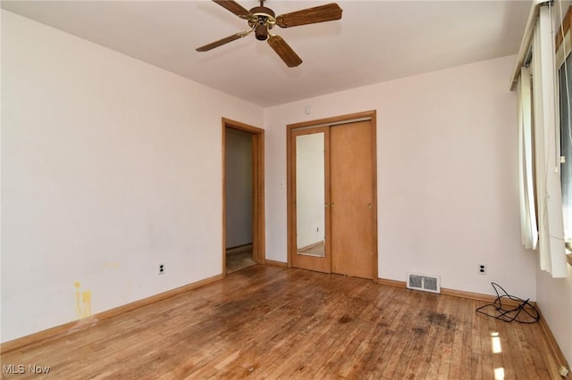 unfurnished bedroom with ceiling fan, a closet, and light wood-type flooring