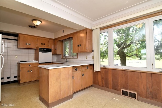 kitchen with sink, white appliances, and kitchen peninsula