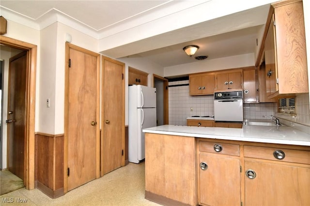 kitchen featuring backsplash, crown molding, sink, and white appliances