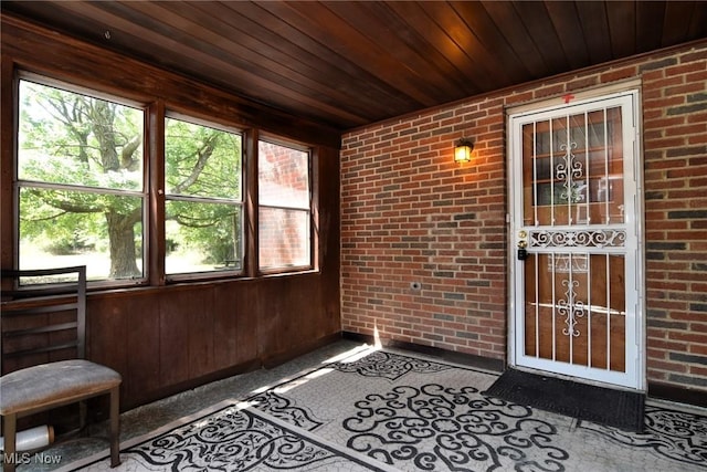 unfurnished sunroom featuring plenty of natural light and wooden ceiling