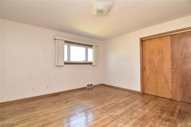 unfurnished bedroom with hardwood / wood-style flooring and a closet