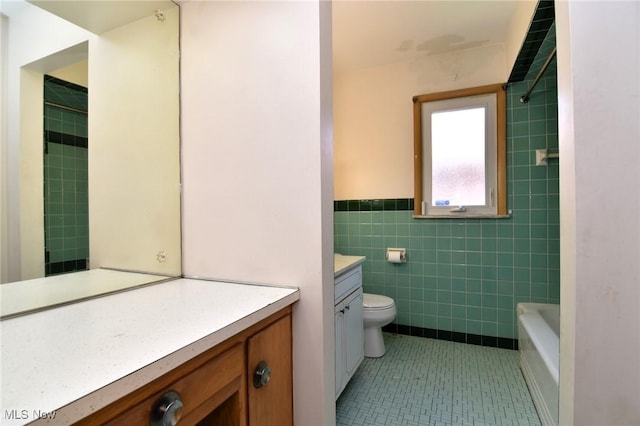 bathroom with vanity, tile walls, and toilet