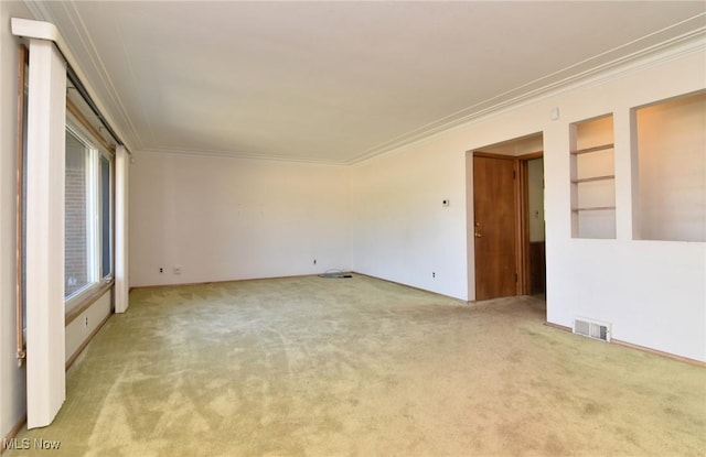 unfurnished room featuring a wealth of natural light, light carpet, and ornamental molding