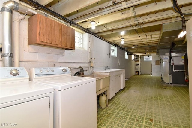 washroom with washer and dryer, heating unit, cabinets, and sink