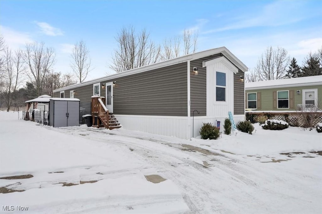 view of snow covered exterior with a shed