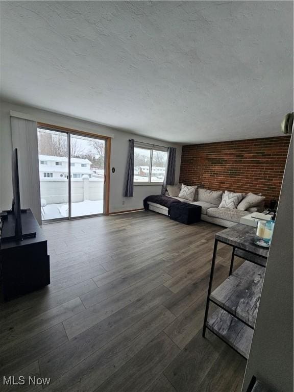 living room featuring dark hardwood / wood-style flooring and brick wall