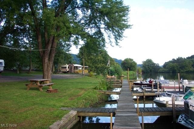 dock area with a water view and a lawn