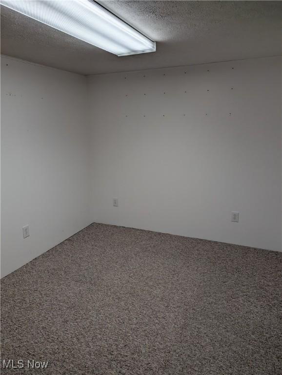 carpeted spare room with a textured ceiling