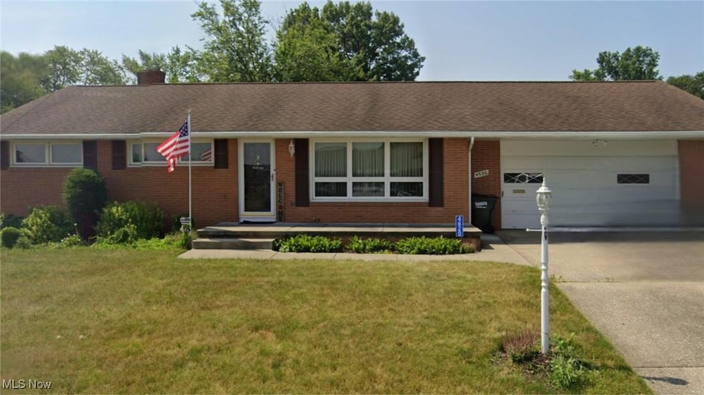 ranch-style home with a front lawn and a garage