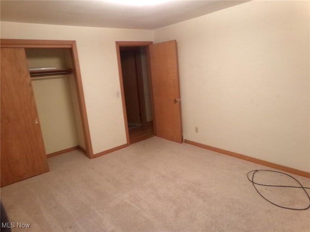 unfurnished bedroom featuring light colored carpet and a closet