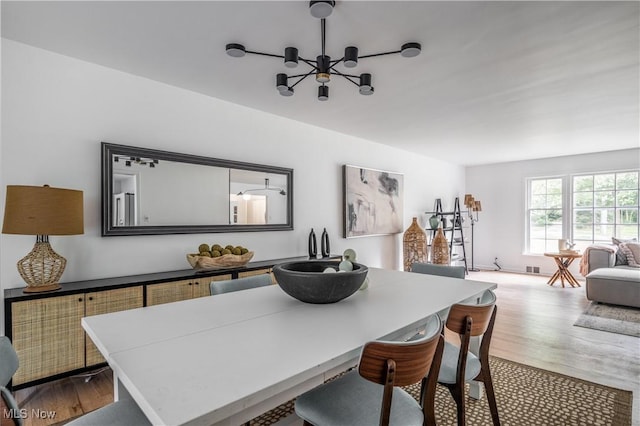 dining area with a notable chandelier and hardwood / wood-style flooring