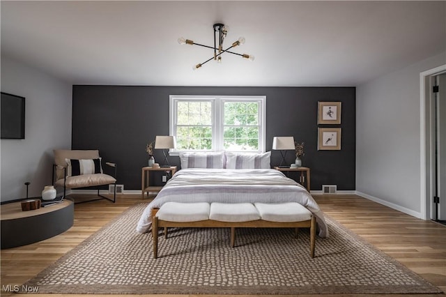 bedroom featuring light hardwood / wood-style flooring and an inviting chandelier