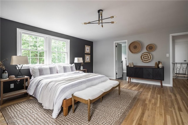 bedroom with hardwood / wood-style flooring and a chandelier