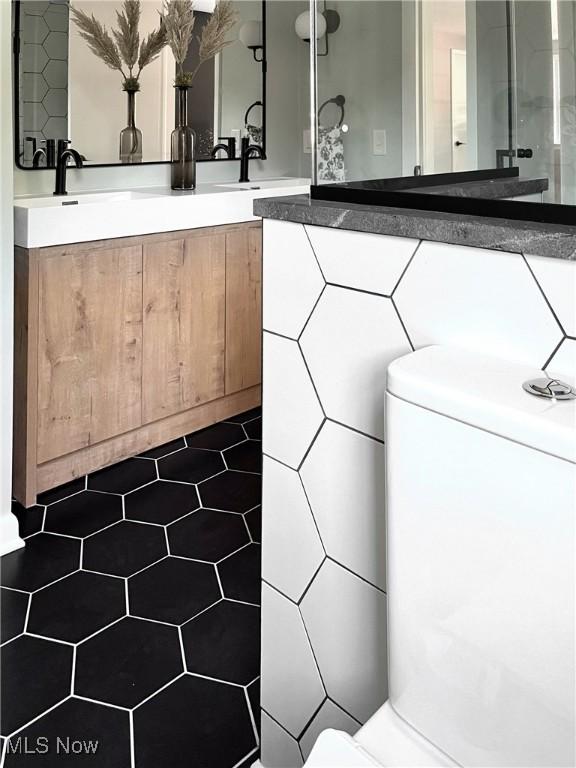 bathroom featuring vanity and tile walls