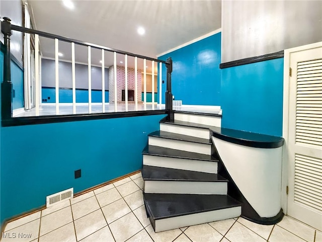 stairway featuring tile patterned floors and ornamental molding