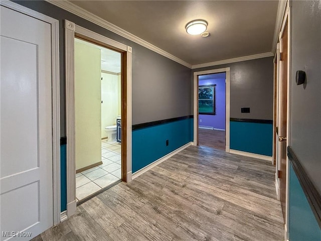 empty room featuring light wood-type flooring and ornamental molding