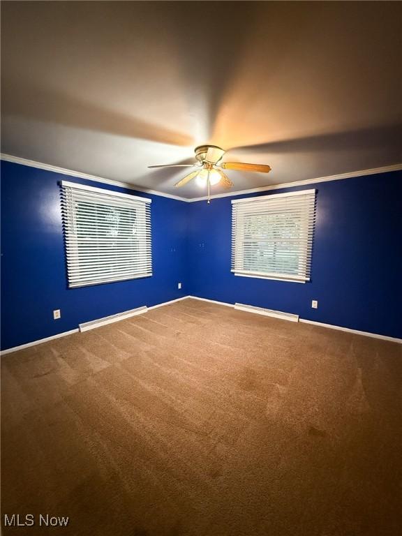 spare room featuring carpet flooring, crown molding, and ceiling fan