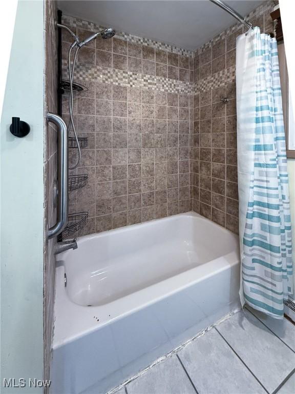 bathroom with tile patterned floors and shower / tub combo with curtain