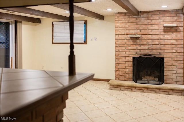 unfurnished living room with beam ceiling, light tile patterned floors, and a brick fireplace