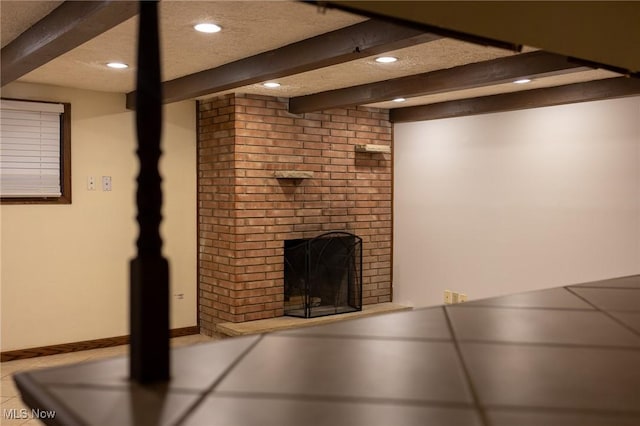 unfurnished living room with beam ceiling, a textured ceiling, and a brick fireplace