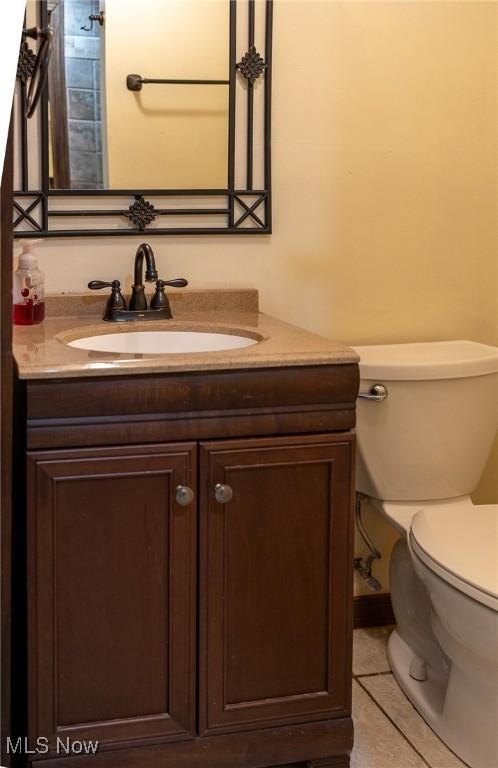 bathroom featuring tile patterned floors, vanity, and toilet