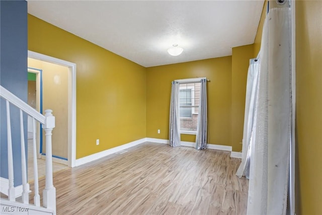 empty room with light hardwood / wood-style flooring