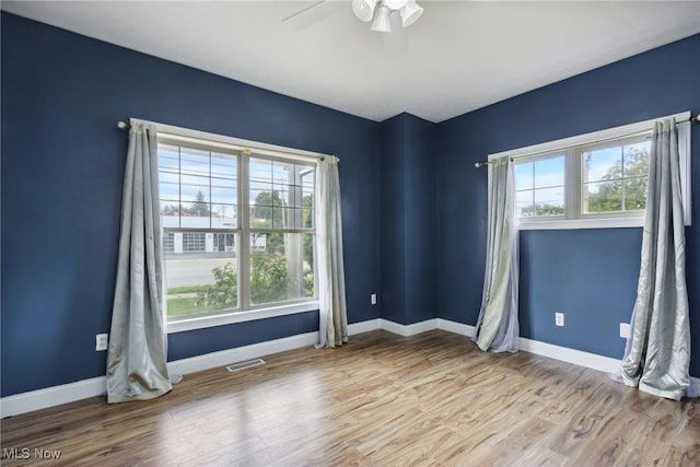 empty room with ceiling fan and light hardwood / wood-style floors