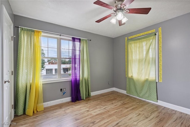 spare room featuring light hardwood / wood-style floors, a wealth of natural light, and ceiling fan