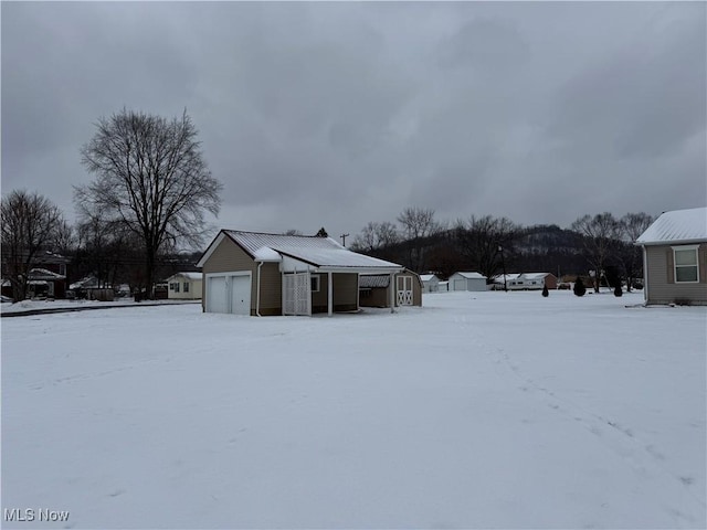 yard layered in snow with an outbuilding