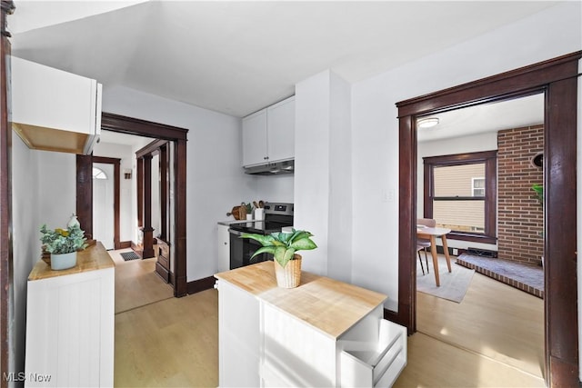 kitchen featuring electric range, white cabinetry, and light hardwood / wood-style flooring