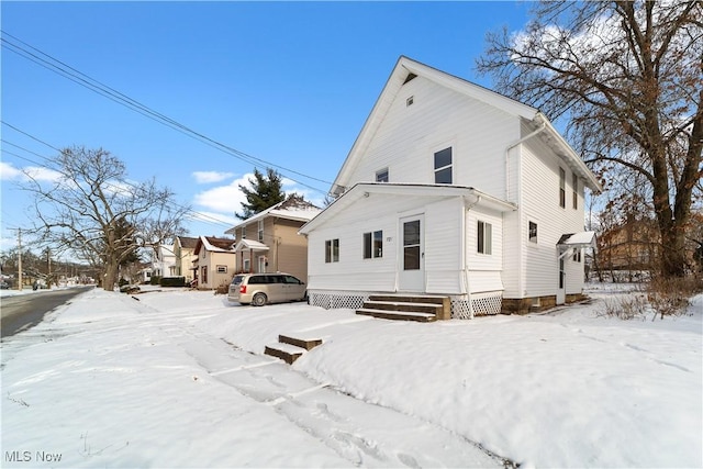 view of snow covered rear of property