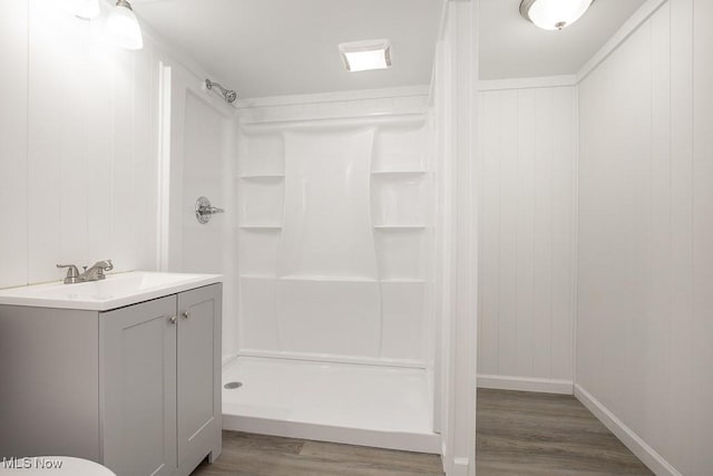 bathroom with vanity, hardwood / wood-style flooring, and walk in shower