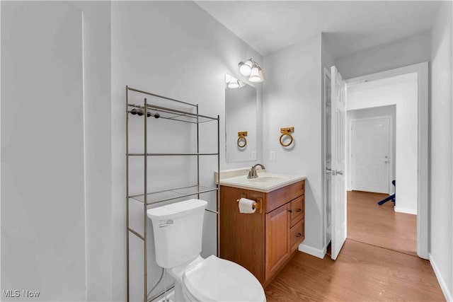 bathroom featuring vanity, wood-type flooring, and toilet