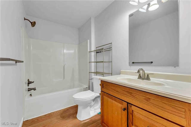 full bathroom with hardwood / wood-style flooring, toilet, vanity, and tub / shower combination