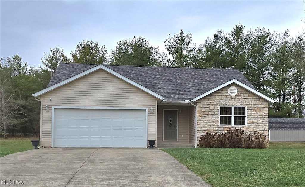 single story home with a garage and a front lawn