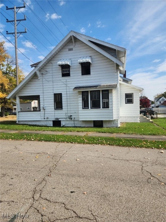 view of side of property with a lawn