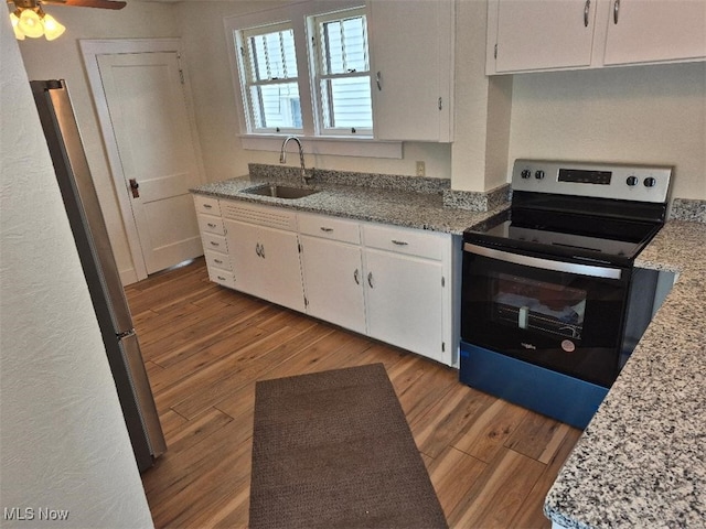 kitchen featuring white cabinetry, stainless steel electric range oven, sink, and light stone countertops