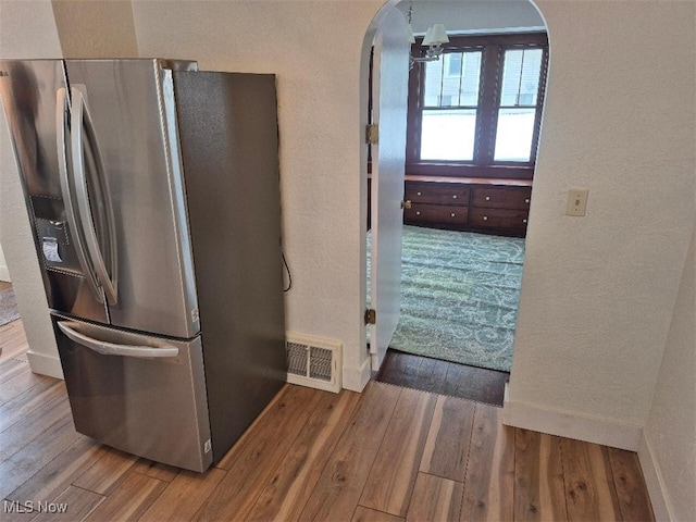 kitchen featuring hardwood / wood-style floors and stainless steel fridge with ice dispenser