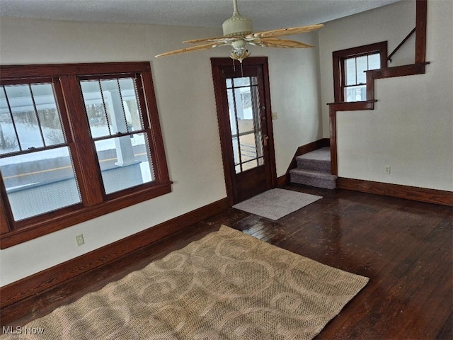 entryway with ceiling fan and dark wood-type flooring