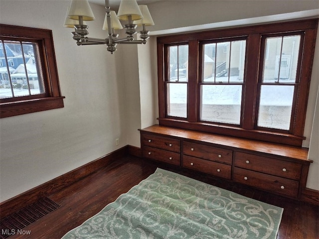 bedroom with dark wood-type flooring and a notable chandelier