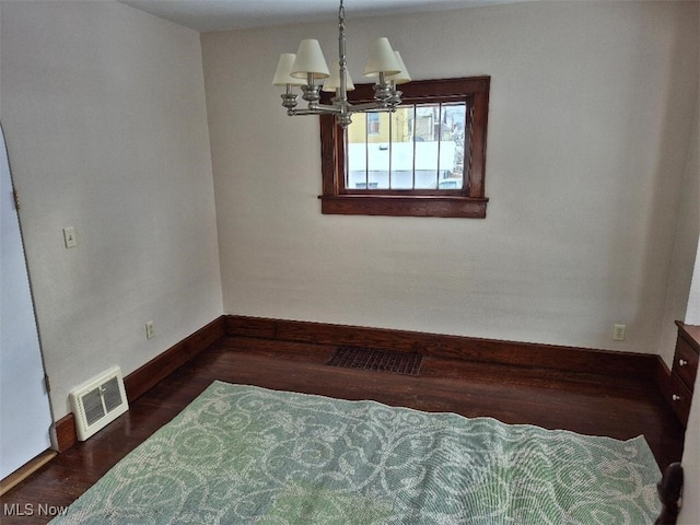 interior space featuring a chandelier and dark hardwood / wood-style flooring