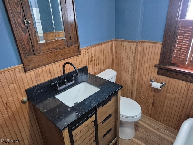 bathroom with hardwood / wood-style floors, vanity, and toilet