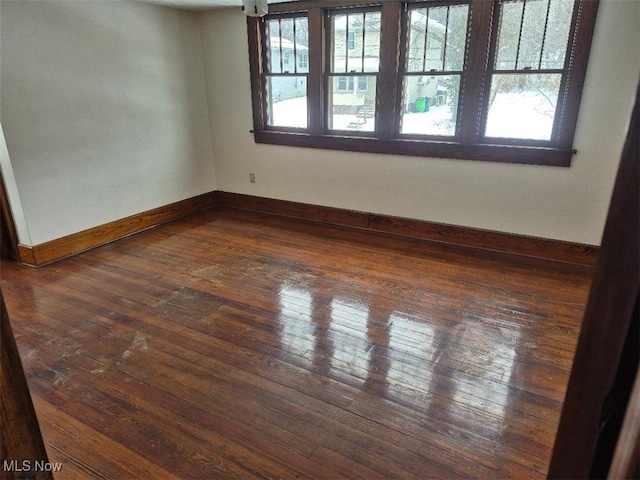 empty room with dark hardwood / wood-style flooring