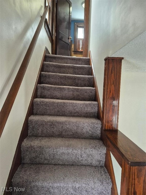 stairway with a textured ceiling